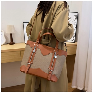 Close-up of beige lychee grain leather tote bag with stylish vertical zipper details