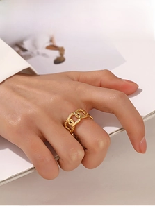 Close-up of golden hammered chain ring on finger showing vintage industrial texture