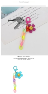 Detail of colorful acrylic chain keychain with smiling flower and resin bear charms