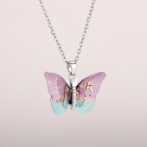 Close-up of butterfly pendant necklace with gradient purple wings and gold foil details