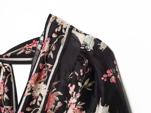 Detailed close-up of floral print on silky black fabric with fine stitching quality