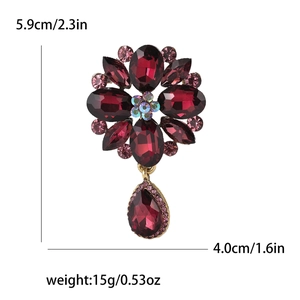 Detailed size view of a gold flower brooch with red rhinestones and water drop pendant