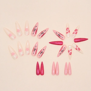 Faux ongles stiletto roses avec motifs étoiles et cœurs et décors en strass