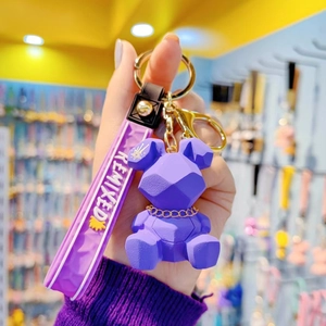 Purple geometric resin rabbit keychain with gold accents and a Remixed wrist strap