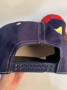 Detail view of the navy blue snapback hat showing the adjustable double-row plastic strap