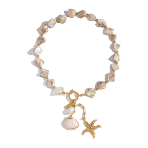 Detailed close-up of ocean-themed necklace with gold starfish and shell charms