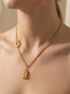 Detail of 18k gold plated rectangular pendant with LOVE engraving on asymmetric chain