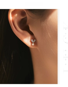 Close-up of s925 silver heart stud earrings with sparkling crystals and a white pearl