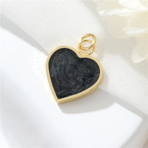 Detailed view of heart charm with black glitter inlay and 14K gold plated frame
