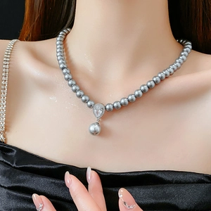 Detail of grey pearl necklace with a sparkling teardrop zircon pendant on a model