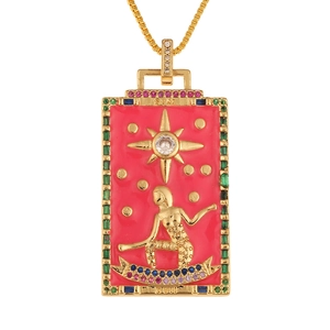 Macro detail of The Star tarot card pendant with pink enamel and green zirconia stones