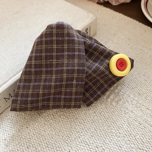 Detailed view of vintage brown plaid fabric hair clip with a yellow button accent