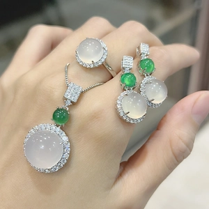 Detail of silver jewelry set with translucent white chalcedony and green gemstones