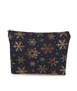 Detail view of golden snowflake pattern on dark blue cosmetic pouch with a top zipper