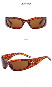 Detail view of Demi-Tea Y2K sunglasses featuring a distinctive metallic crescent moon logo
