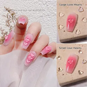 3D transparent heart resin nail charms in large and small sizes on gradient pink nails