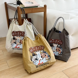 Three embroidered cat illustration nylon tote bags in beige, yellow and dark grey