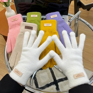 Detailed texture of thick knit gloves showing plush wool material and ribbed cuffs