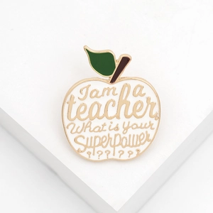 Detailed view of apple brooch with I am a teacher What is your Superpower text