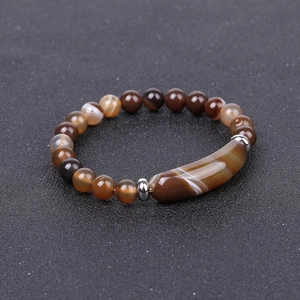 Detailed macro view of agate bracelet featuring brown tiger stone beads and curved tube bar