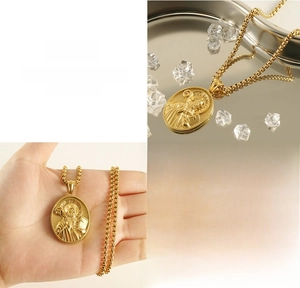 Macro detail of 3D embossed St. Benedict gold medal pendant in durable titanium steel