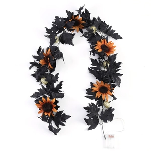 Detail of Halloween garland with black maple leaves, orange sunflowers and LED light box