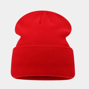 Detailed close-up of ribbed texture on red cuffed knit beanie for winter warmth