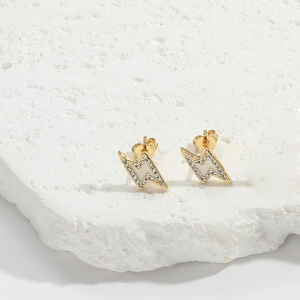 Detail of lightning bolt earrings with gold plating, white enamel, and pavé set zircons