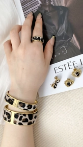 Detail shot of leopard print fur and gold metal jewelry set with ring and earrings