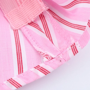 Macro shot of pink and white striped fabric showing detailed stitching and edge binding