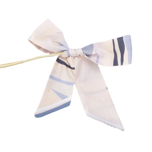 Retro striped bow hair ribbon scarf in pink and blue tied on a wooden branch