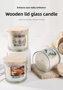Three scented candles in glass jars with wooden lids arranged on natural stone stands