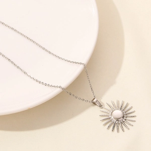 Dettaglio della collana d'argento con ciondolo a sole radiante su catena a maglie sottili