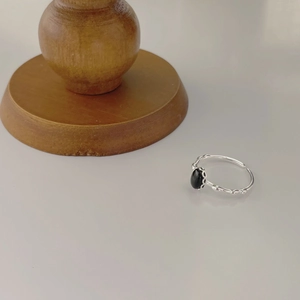 Macro shot of silver adjustable ring with black oval stone and textured band