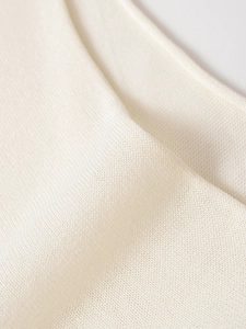 Macro shot of cream white lightweight plain knit fabric with fine needlework texture