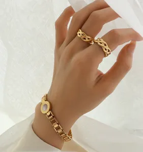 Detail of gold-plated Roman numeral bangle with mother of pearl and woven rings