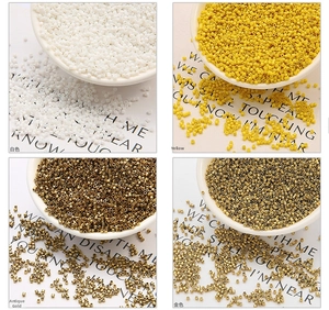 Macro detail of 2mm glass seed beads in white, yellow, antique gold and bright gold