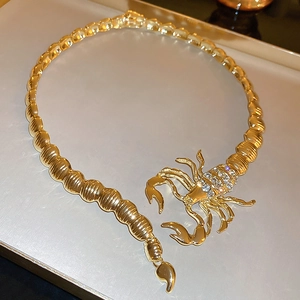 Detailed close-up of a gold-toned scorpion necklace with sparkling crystal rhinestones