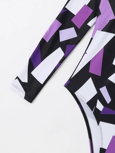 Détail d'un maillot de bain à manches longues avec motifs géométriques violets et noirs