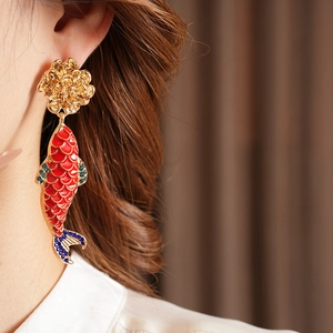 Close-up of vintage koi fish earring with red enamel and sparkling blue rhinestones