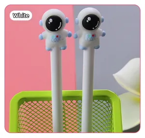 Close-up of cute white astronaut pens in a green mesh pen holder on a pink desk background