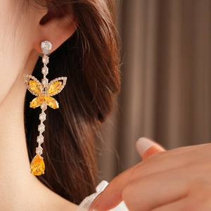 Detailed view of butterfly drop earrings with yellow crystals and sparkling zircons
