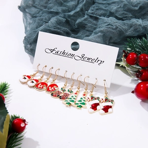 Detailed set of six pairs of Christmas enamel earrings on a fashion jewelry display card