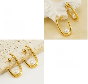 Detail view of U-shaped gold earrings with polished finish and elegant white pearl drop