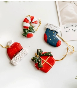 Detailed view of resin Christmas ornaments set including red hat, stocking and gift box