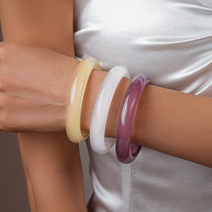 Three minimalist resin geometric round bangles in yellow, white, and purple colors