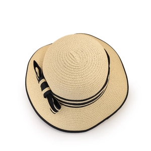 Détail d'un chapeau de paille élégant avec un nœud noir classique et une texture tissée