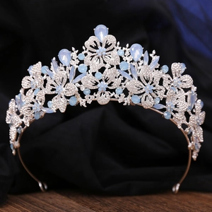 Detail of silver bridal crown featuring leaf motifs and teardrop blue crystals