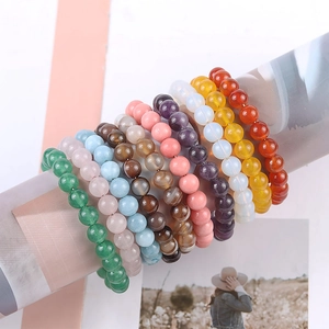 Handmade 8mm natural stone beaded bracelets in various colors on a display stand