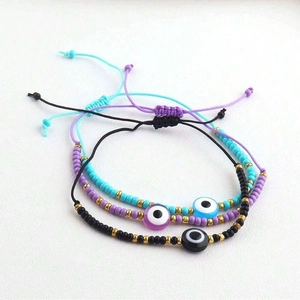 Three-piece evil eye bead bracelets set with adjustable woven cords in purple and blue